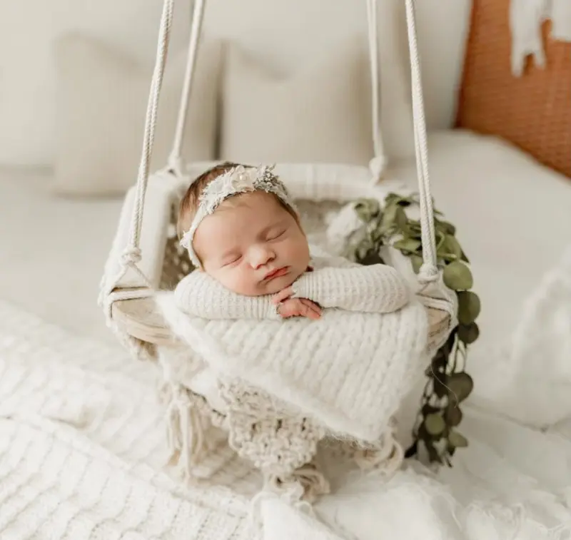 Sleeping newborn wrapped in a soft hanging basket setup showing scale and calm styling - newborn photography prop - Dvotinst
